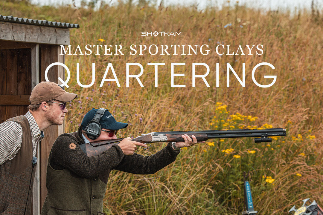 Sporting clays training session featuring a coach and shooter focusing on quartering targets in a grassy field.